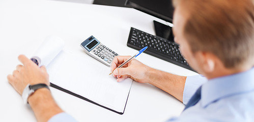 Image showing businessman with notebook and calculator