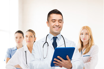 Image showing smiling male doctor with tablet pc at hospital