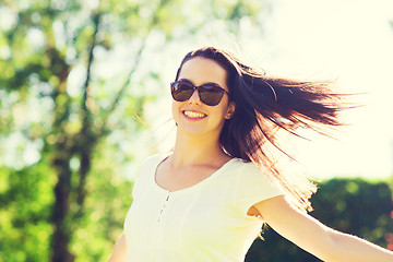 Image showing smiling young woman with sunglasses in park