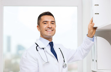 Image showing happy doctor with clipboard in medical office