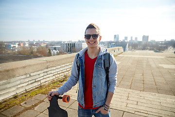Image showing smiling man or teenager with longboard on street