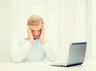 Image showing stressed old man filling a form at home