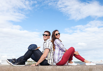 Image showing teenagers sitting back to back