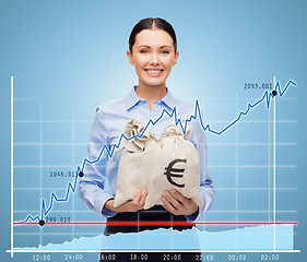 Image showing businesswoman holding money bags with euro