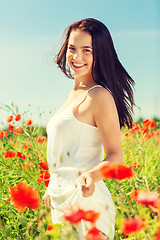 Image showing smiling young woman on poppy field