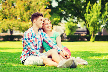 Image showing smiling couple sitting on grass in park