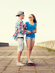 Image showing smiling couple with skateboard outdoors