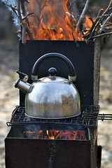 Image showing the whistling kettle begins to boil on a brazier