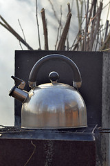 Image showing the whistling kettle begins to boil on a brazier.