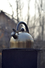 Image showing the whistling kettle begins to boil on a brazier.