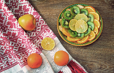 Image showing Fruits and beautiful old towel on the table surface.