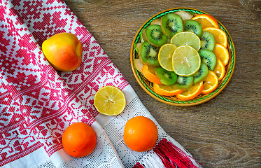 Image showing Fruits and beautiful old towel on the table surface.