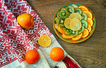 Image showing Fruits and beautiful old towel on the table surface.