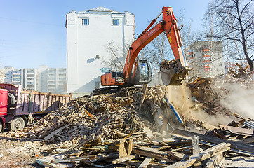 Image showing Excavator loads garbage from demolished house