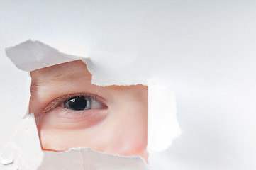 Image showing Cute baby boy looking through paper hole 