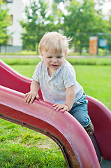 Image showing Baby kid standing on red slide