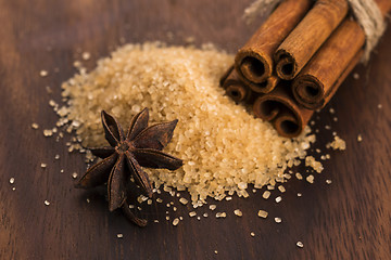 Image showing Cinnamon sticks with pure cane brown sugar on wood background