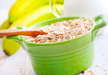 Image showing Oat flakes in the green bowl with banana and milk