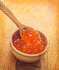 Image showing Red salmon caviar in the wooden bowl and spoon