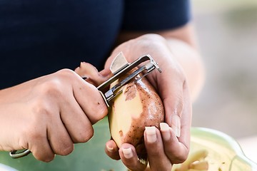 Image showing Potato is peeled with a kitchen knife