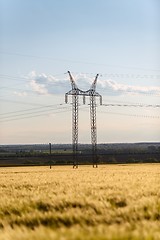 Image showing Large transmission tower with field