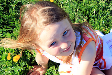 Image showing little girl lying on the grass with dandelions