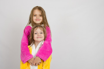 Image showing Girl in bathrobe hugging her sister a bathrobe