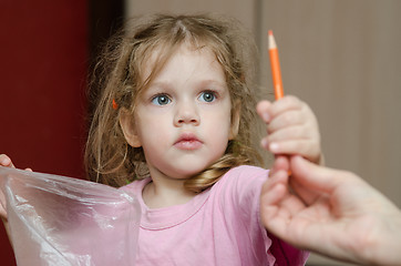 Image showing Girl takes from the hands of moms pencil