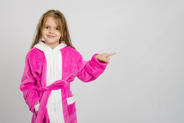 Image showing Six year old girl in bathrobe pointing at empty space