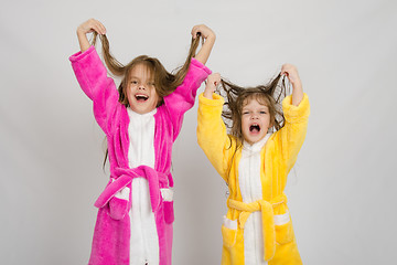Image showing Two girls in the bath robes grimace hair