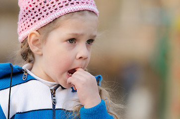 Image showing Girl in thought stuck a finger her mouth