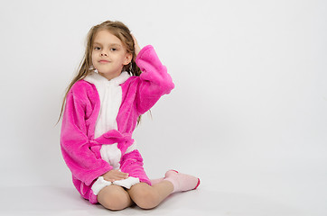 Image showing Six year old girl in a bathrobe straightens hair