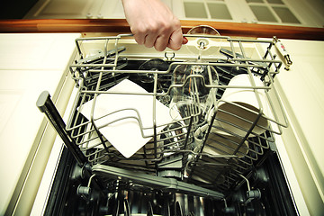 Image showing Kitchen Woman with a clean wine glass on background dishwasher