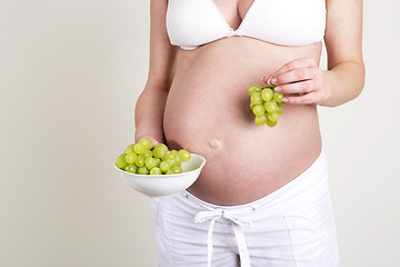 Image showing Pregnant woman with a bowl of grapes in her hands