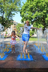 Image showing mother and daughter playing in fountains