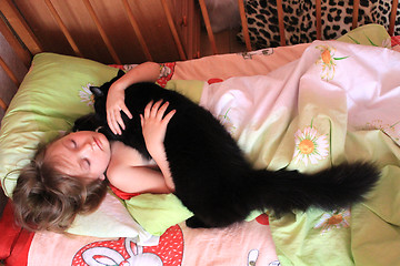 Image showing girl playing with her cat in the bed