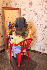 Image showing girl makes up her face before a mirror