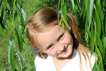 Image showing girl smiling besides the leaves of willow