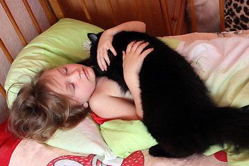 Image showing girl playing with her cat in her bed