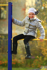 Image showing blue-eyed girl on the horizontal bar