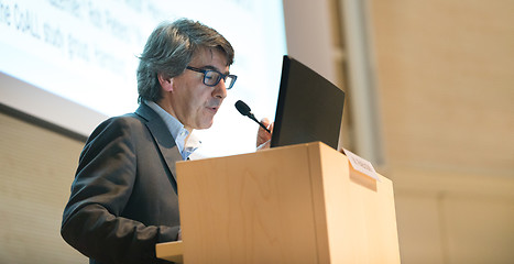 Image showing Speaker giving talk on podium at Business Conference.