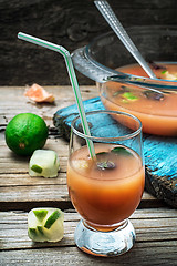 Image showing fresh juice of tropical citrus fruits on wooden background