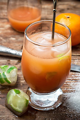 Image showing fresh juice of tropical citrus fruits on wooden background