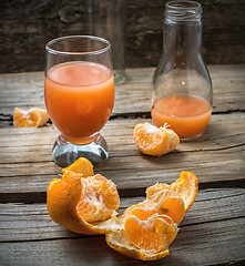 Image showing fresh juice of tropical citrus fruits on wooden background