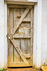 Image showing old wooden door with danger sign