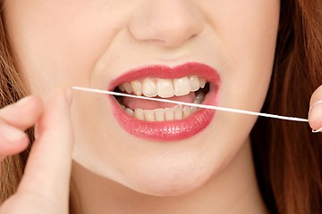 Image showing Woman using dental floss