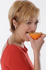 Image showing Woman eating orange