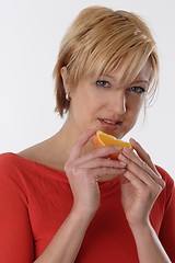 Image showing Woman eating orange