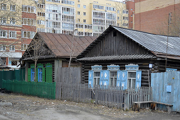 Image showing Old wooden houses against modern high-rise buildings. Tyumen, Ru