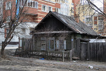 Image showing Old wooden houses against modern high-rise buildings. Tyumen, Ru